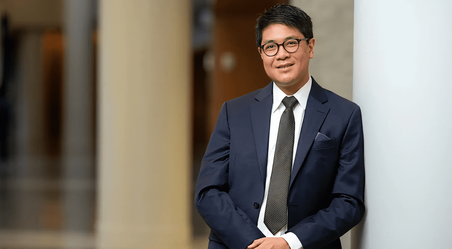 A man wearing black suit standing