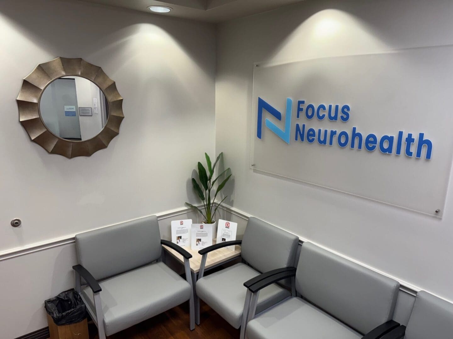 Clinic waiting area with chairs and signage.
